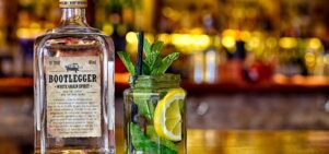 Photo of a bottle of 'Bootlegger' white grain spirit next to a jar with mint