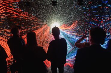 Silhouette of people standing in front of an exhibit at Manchester Science Festival 2018