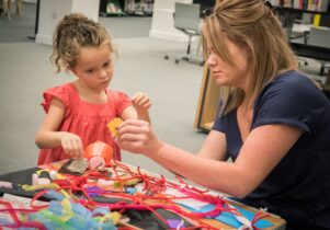 Woman making dream catchers with a young girl