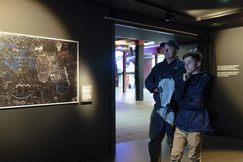 Father and son watching a video in Stephen Hawking at Work display