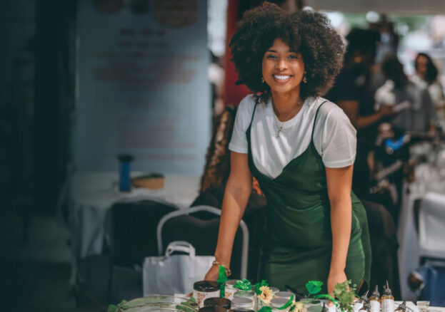 Naanu stood at her stall wearing a green dress