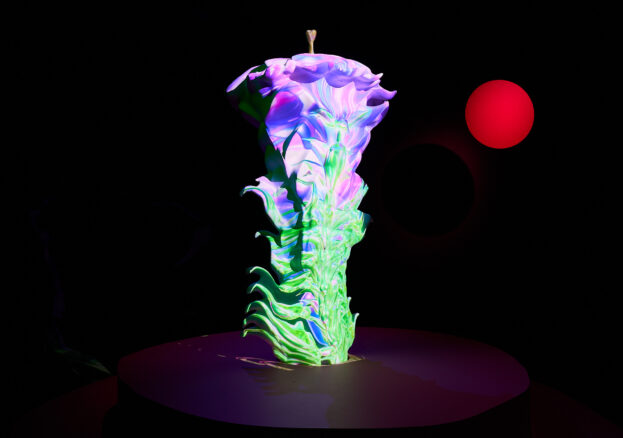 A sculpture of a flower, lit with a purple and green animation. To the right of the sculpture is a red, floating circle.