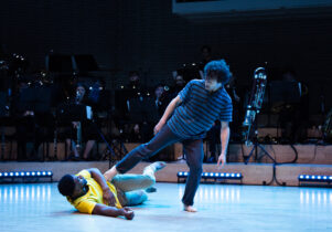 Two dancers and orchestra on stage