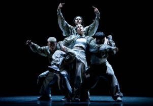 Cycles at Aviva Studios: Boy Blue in dynamic poses, wearing coordinated streetwear outfits, performing against a dark background.