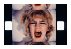 A film still, showing a woman's face screaming.