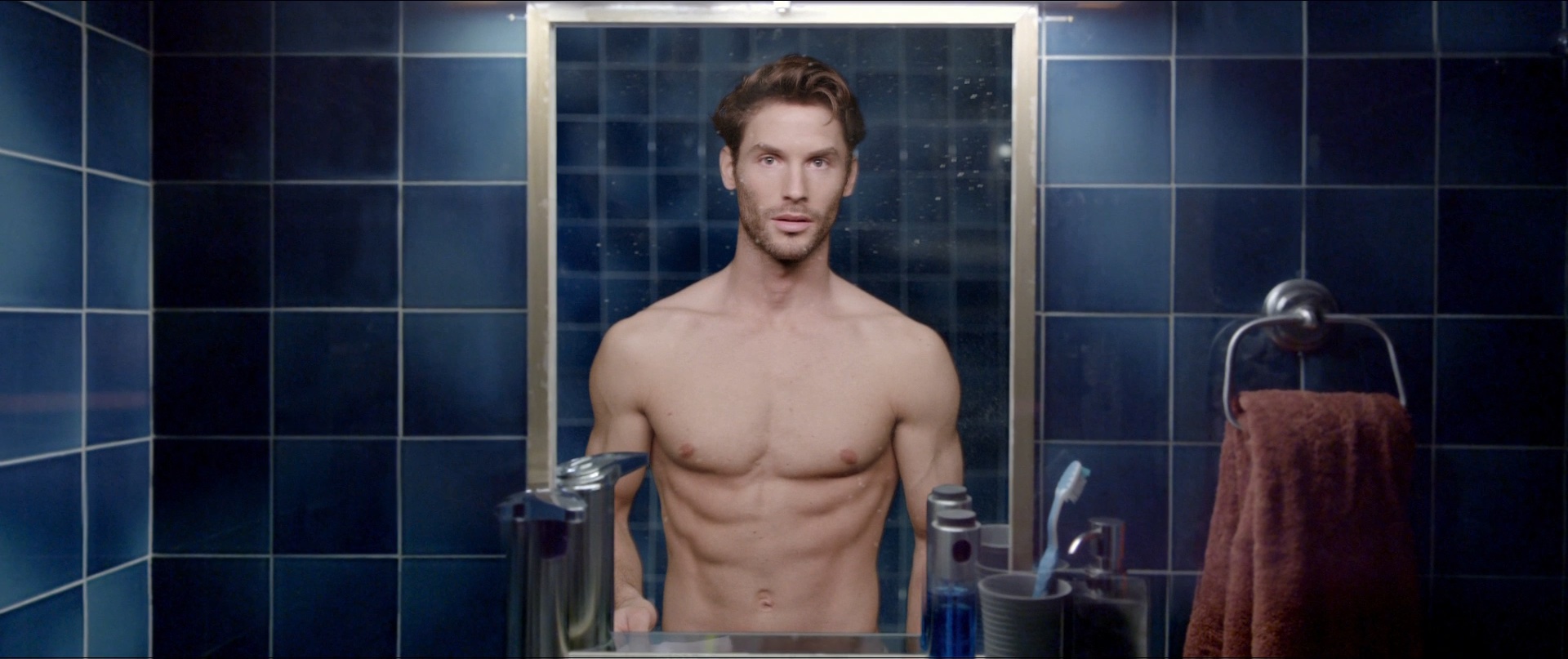 An attractive man looking in the mirror