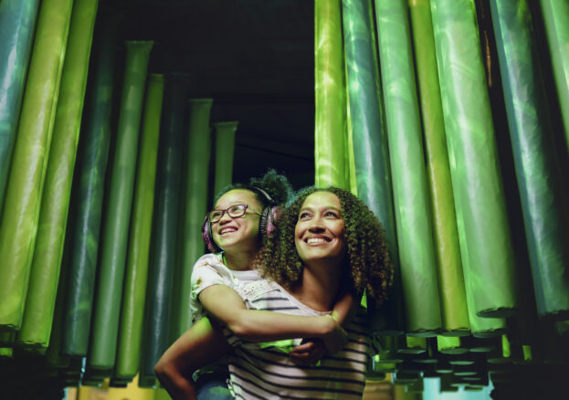 Mother and daughter wearing ear defenders in small intestine in Operation Ouch! Food, Poo and You Summer of senses at the Science and Industry Museum