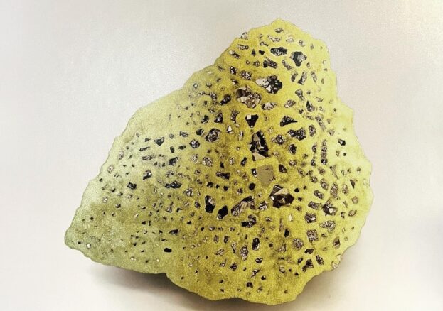 Artwork by Lorna Johnson that shows a lack and white photo of a rock containing fools gold, this has been drawn on with an elaborate net of gold pen that covers all contours of the rock.