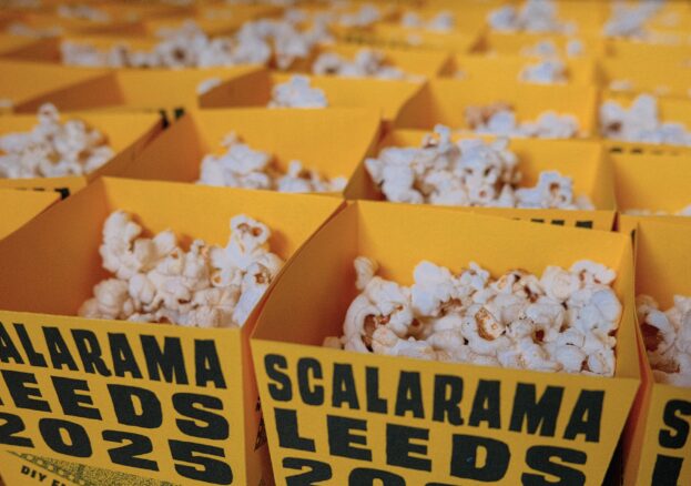 a group of popcorn tubs that are branded yellow saying scalarama leeds 2025
