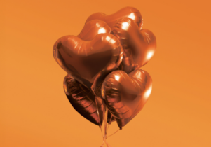 An orange background with dark orange balloons in the shape of hearts.