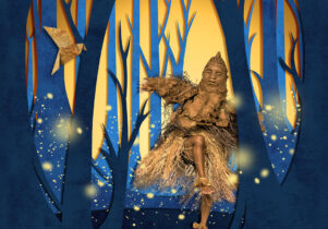 A dancer wearing a light brown costume and puppet mask, moves in a glowing forest of tall blue and golden trees, surrounded by floating firefly-like lights.