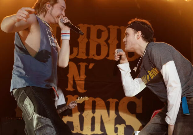 Two young men performing on stage, dressed in Grunge attire.