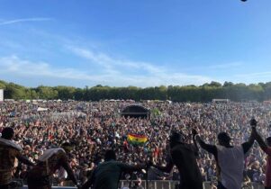 A band taking a bow in front of a packed festival crowd.