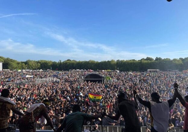 A band taking a bow in front of a packed festival crowd.
