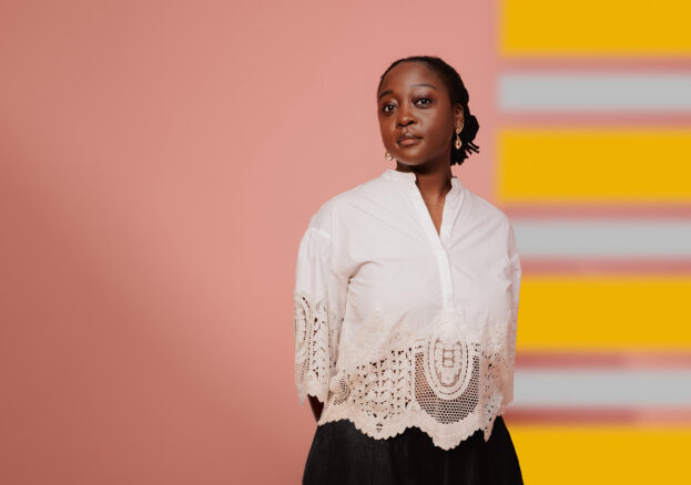 Cassie Kinoshi standing in front of a colourful background