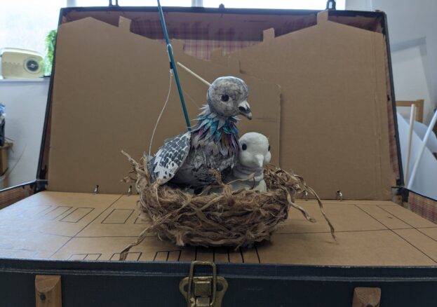 Image of puppet pigeons in a nest.